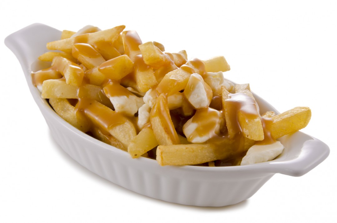 Poutine, traditional fast food in Quebec, Canada. Closeup.