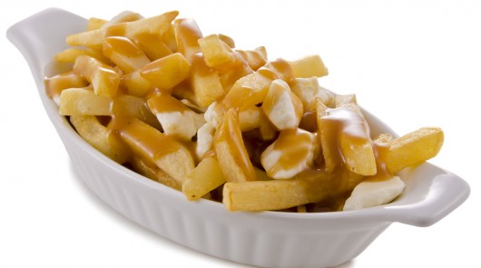 Poutine, traditional fast food in Quebec, Canada. Closeup.